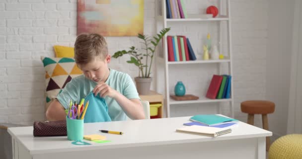 Zdenerwowany Mały Chłopiec Dużą Ilością Pracy Domowej Zrobienia Siedzi Przy — Wideo stockowe