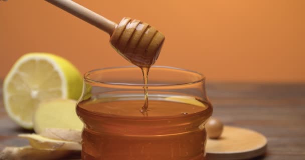 甘い蜂蜜はガラス瓶の中のディップから注ぎます クローズアップ — ストック動画