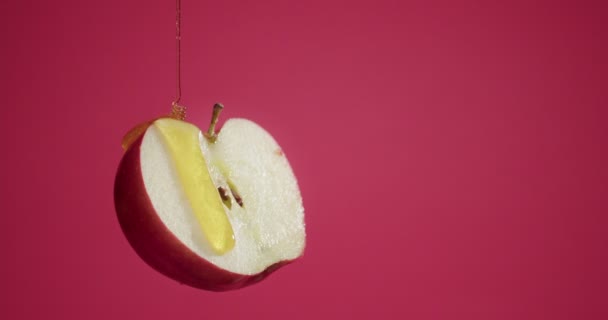 Выливание Сладкого Меда Половину Спелого Яблока Цветном Фоне — стоковое видео