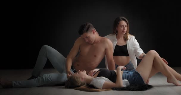 Knappe Man Twee Mooie Vrouwen Een Donkere Achtergrond Polyamoreel Concept — Stockvideo