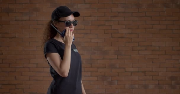 Female African American Security Guard Two Way Radio Brick Background — Stock Video
