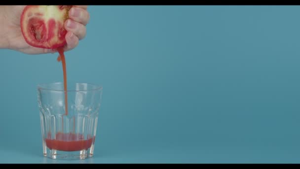 Kvinna Pressa Juice Från Tomat Glas Färg Bakgrund — Stockvideo