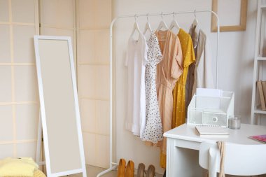 Şık bir odanın içinde giysi ve aynalarla dizilin.