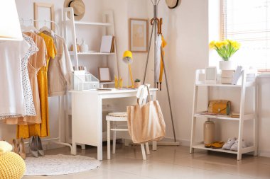 Modern iş yeri ve şık kadın kıyafetleriyle dolu bir oda.