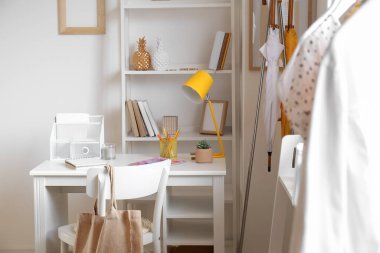 Modern iş yeri ve şık kadın kıyafetleriyle dolu bir oda.