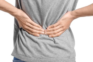 Beyaz arka planda sırt ağrısı çeken genç bir adam.