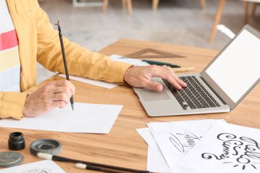 Evde çalışan genç bir kaligraf.