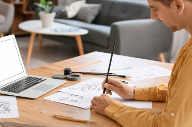 Evde çalışan genç bir kaligraf.