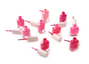 Beyaz arka planda tırnak cilası ve fırça şişeleri açılmış.