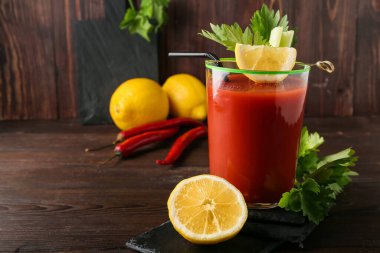 Kanlı Mary kokteyli ve ahşap arka plandaki malzemelerden oluşan bir kompozisyon.