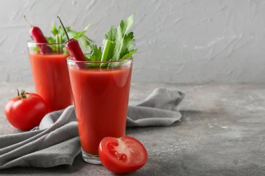 Kırmızı biber ve domateslerle süslenmiş kırmızı biberli bir bardak Bloody Mary kokteyli.