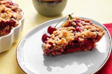 Renkli arka planda lezzetli vişneli turta ile tabak, yakın plan.