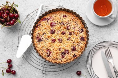 Lezzetli vişneli turta ve arka planda bir fincan çay ile pişirme yemeği.