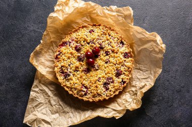 Koyu arkaplanda vişneli turtalı parşömen.