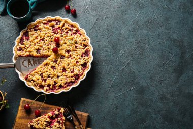 Lezzetli kirazlı fırın yemeği ve renkli arka planda bir fincan çay.