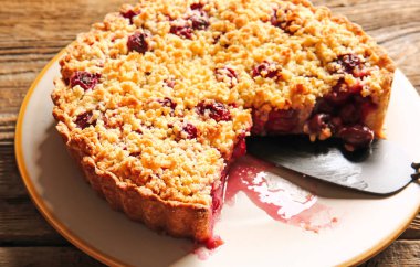 Ahşap arka planda lezzetli vişneli turta tabağı, yakın plan.