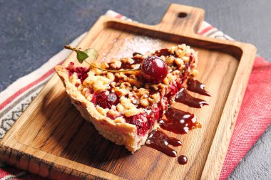 Koyu arkaplanda lezzetli vişneli turta olan tahta, yakın plan.