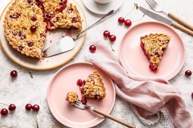 Açık arkaplanda lezzetli vişneli turta parçaları olan tabaklar