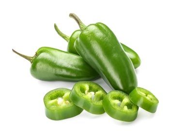 Beyaz arka planda yeşil biber ve dilimler.