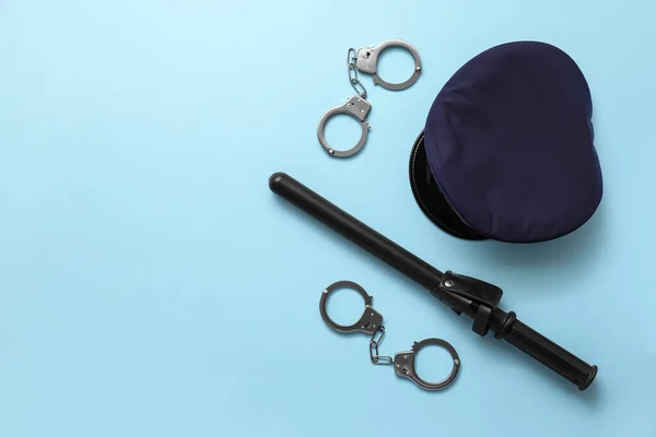 警察官の帽子 バトン 手錠の色の背景 — ストック写真