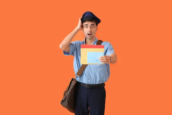 Renkli Arkaplanda Mektupları Olan Şaşırmış Genç Bir Postacı — Stok fotoğraf
