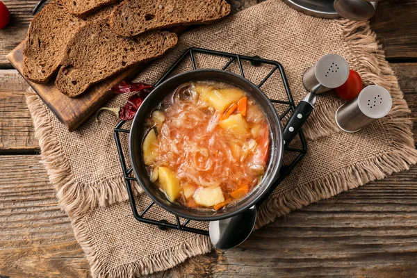 Schüssel Mit Leckerer Sauerkrautsuppe Und Frischen Brotscheiben Auf Holzgrund — Stockfoto