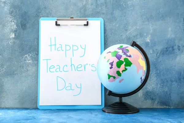 Clipboard with text HAPPY TEACHER\'S DAY and globe on color background