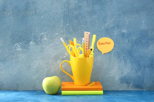 色の背景に文房具やリンゴを持つ単語教師 — ストック写真