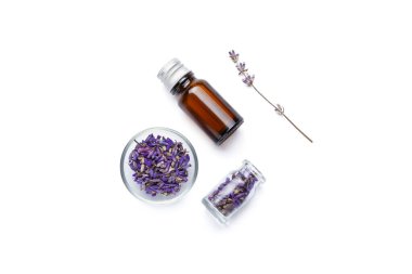 Beyaz arka planda bir şişe gerekli yağ ve lavanta çiçeği.