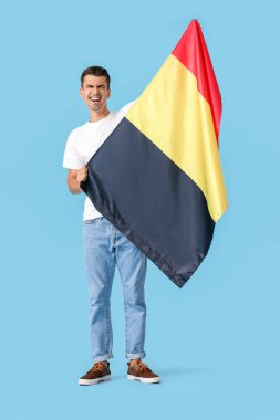 Emotional man with flag of Belgium on color background clipart