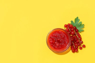 Bir kase lezzetli kırmızı frenk üzümü reçeli ve renkli böğürtlen.