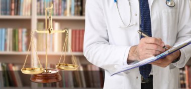 Kütüphanede adalet terazisi olan erkek doktor
