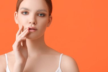 Renkli arka planda boyalı kaşları olan güzel bir genç kadın.