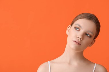 Renkli arka planda boyalı kaşları olan güzel bir genç kadın.