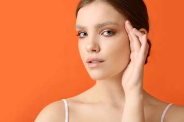 Renkli arka planda boyalı kaşları olan güzel bir genç kadın.