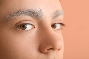 Renkli arka planda boyalı kaşları olan genç çocuk, yakın plan.