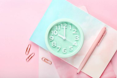 Renk arkaplanı üzerindeki alarm saati ve kırtasiye malzemesini biçimlendir