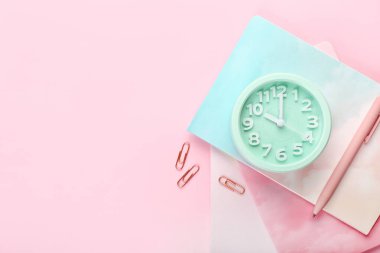 Renk arkaplanı üzerindeki alarm saati ve kırtasiye malzemesini biçimlendir