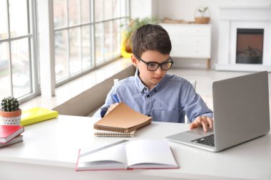 Küçük okul çocuğu evde online çalışıyor.