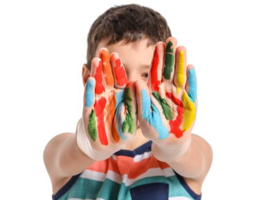 Beyaz arka planda elleri boyalı küçük bir çocuk.