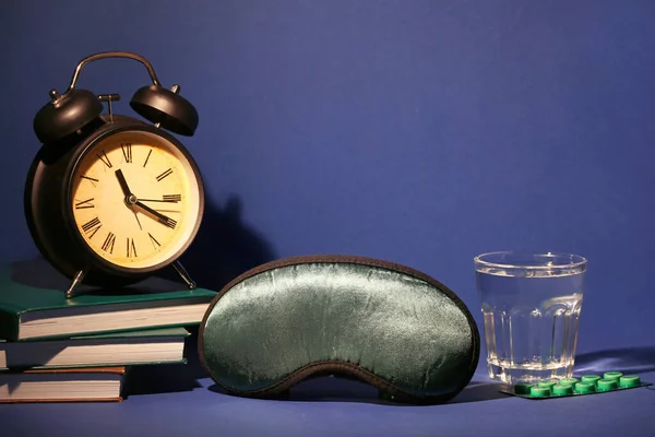 目覚まし時計 水と色の背景に薬のガラスと睡眠マスク — ストック写真