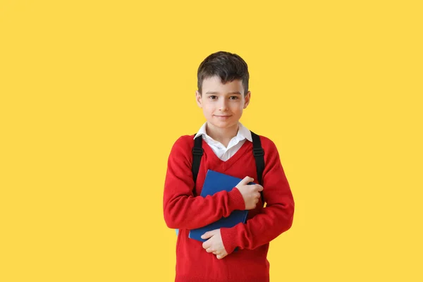色の背景に本を持つ小さな学校の少年 — ストック写真