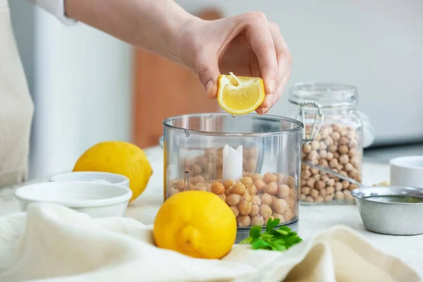 Woman Squeezing Lemon Blender Chickpeas Table Kitchen Closeup — Stock Photo, Image
