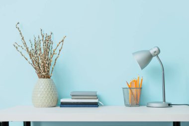 Lambalı, not defterli ve renk duvarına yakın kırtasiyeli şık bir iş yeri