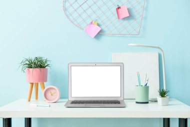 Ofiste renk duvarının yanında dizüstü bilgisayarı olan modern çalışma alanı