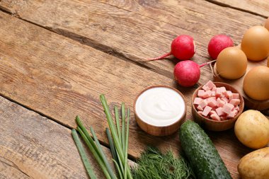 Ahşap arka planda okroshka için farklı malzemeler.