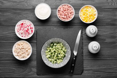 Koyu ahşap arka planda okroshka için farklı malzemeler içeren kaseler.