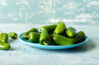 Renkli arka planda yeşil biberli tabak, yakın plan.