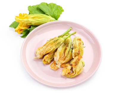 Beyaz arka planda kızarmış kabak çiçekli tabak.