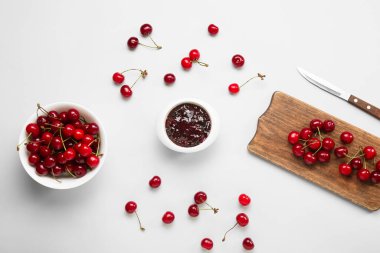 Beyaz arka planda olgun kiraz ve reçelli kompozisyon